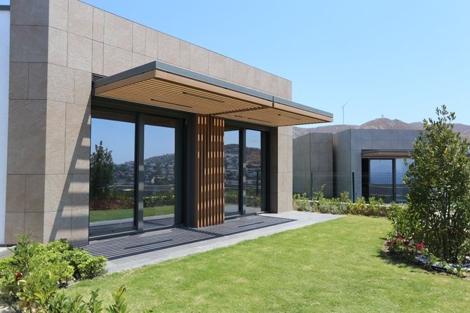 Außenansicht einer modernen Villa mit Steinfassade und Garten